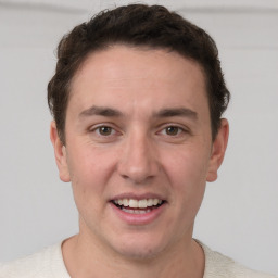 Joyful white young-adult male with short  brown hair and grey eyes