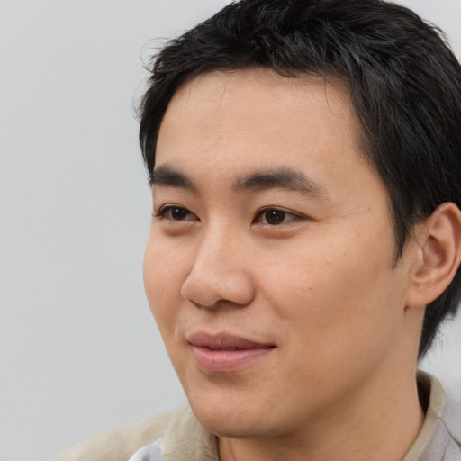 Joyful asian young-adult male with short  black hair and brown eyes