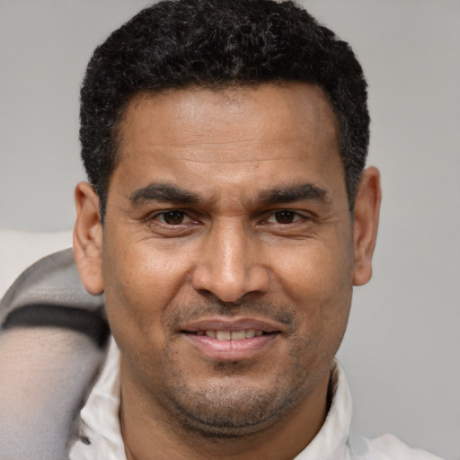 Joyful latino adult male with short  brown hair and brown eyes