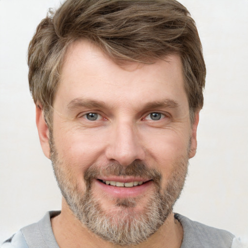 Joyful white adult male with short  brown hair and grey eyes