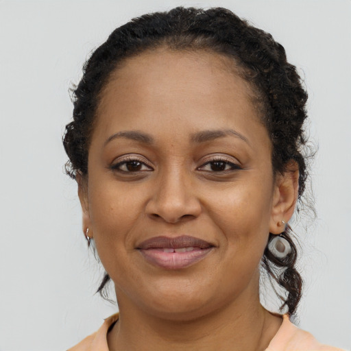 Joyful black adult female with long  brown hair and brown eyes