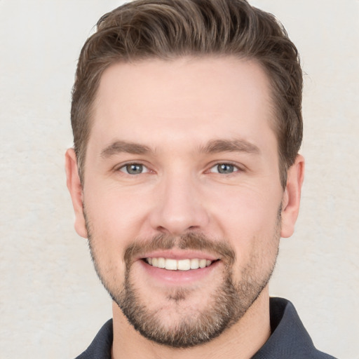 Joyful white young-adult male with short  brown hair and grey eyes