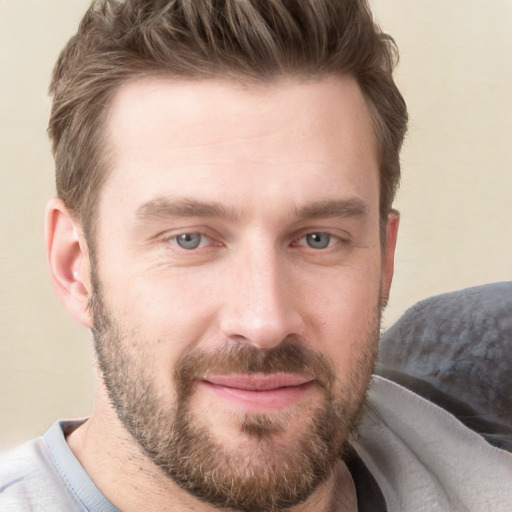 Joyful white young-adult male with short  brown hair and grey eyes