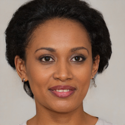 Joyful black young-adult female with short  black hair and brown eyes