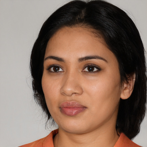 Joyful latino young-adult female with medium  black hair and brown eyes