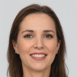 Joyful white young-adult female with long  brown hair and grey eyes