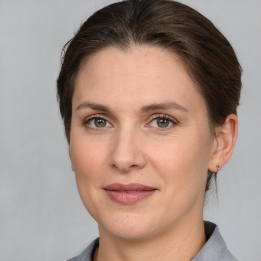 Joyful white adult female with medium  brown hair and grey eyes