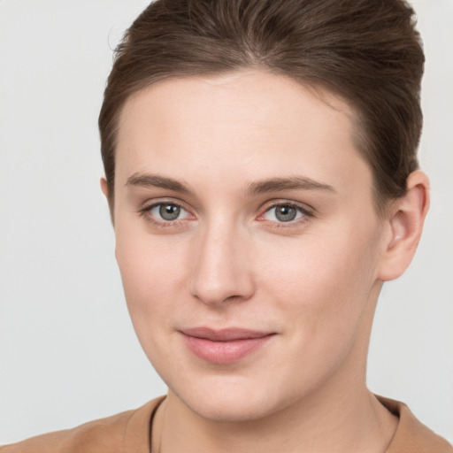 Joyful white young-adult female with short  brown hair and grey eyes