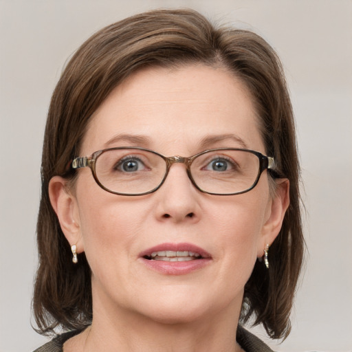 Joyful white adult female with medium  brown hair and blue eyes