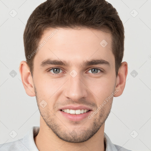 Joyful white young-adult male with short  brown hair and grey eyes