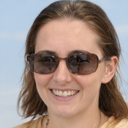 Joyful white adult female with medium  brown hair and blue eyes