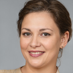 Joyful white adult female with medium  brown hair and brown eyes