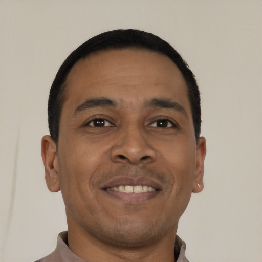Joyful latino young-adult male with short  brown hair and brown eyes