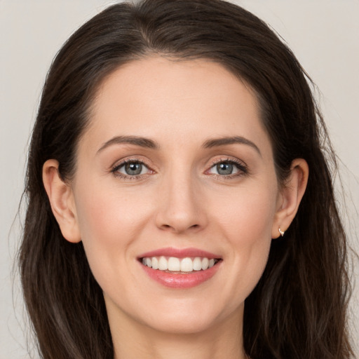 Joyful white young-adult female with long  brown hair and grey eyes