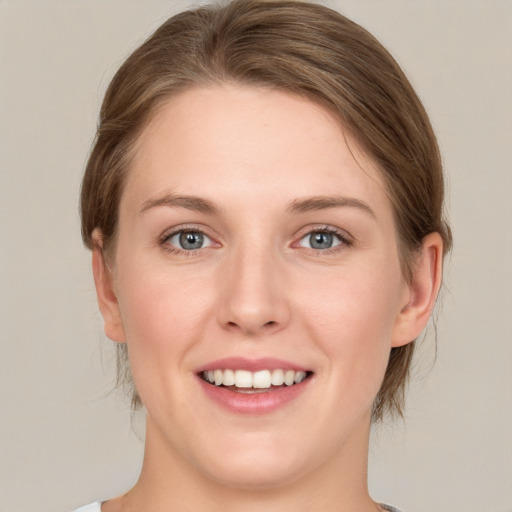 Joyful white young-adult female with medium  brown hair and grey eyes