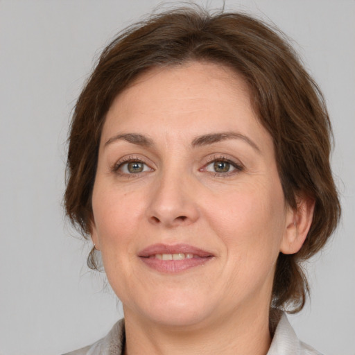 Joyful white adult female with medium  brown hair and grey eyes