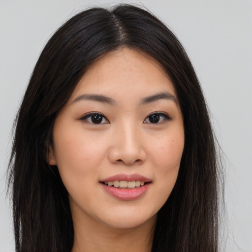 Joyful asian young-adult female with long  brown hair and brown eyes