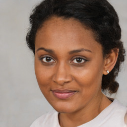 Joyful black young-adult female with medium  brown hair and brown eyes