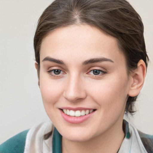 Joyful white young-adult female with medium  brown hair and grey eyes