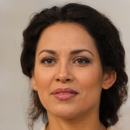 Joyful latino adult female with medium  brown hair and brown eyes