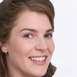 Joyful white young-adult female with long  brown hair and blue eyes