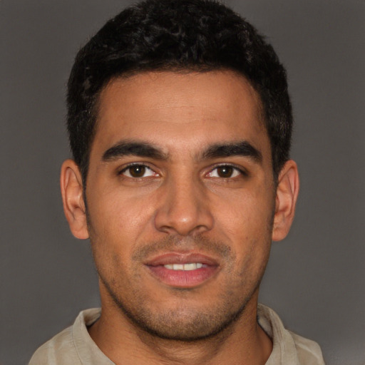 Joyful latino young-adult male with short  brown hair and brown eyes