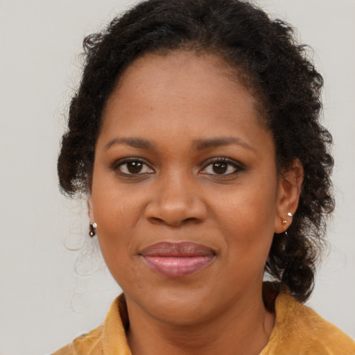 Joyful black adult female with long  brown hair and brown eyes