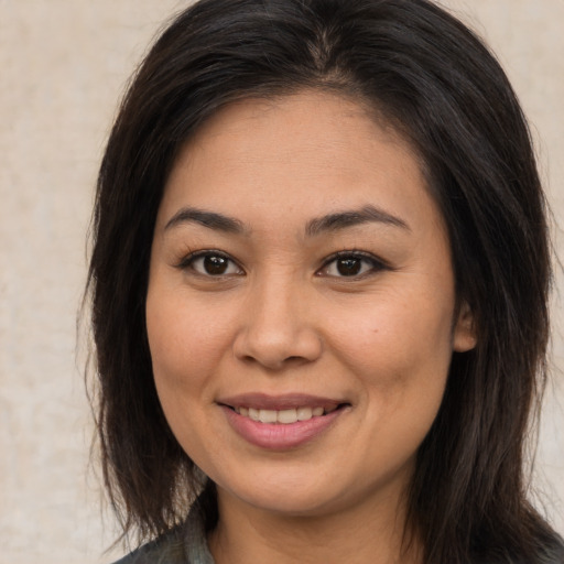 Joyful asian young-adult female with long  brown hair and brown eyes