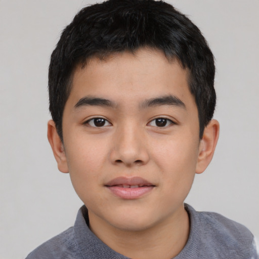 Joyful asian child male with short  black hair and brown eyes