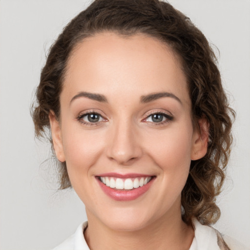 Joyful white young-adult female with medium  brown hair and green eyes