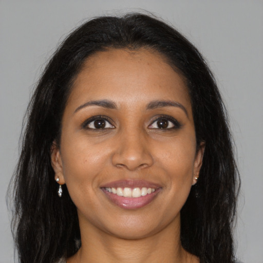 Joyful black young-adult female with long  brown hair and brown eyes
