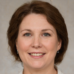 Joyful white adult female with medium  brown hair and grey eyes