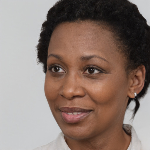 Joyful black adult female with short  brown hair and brown eyes