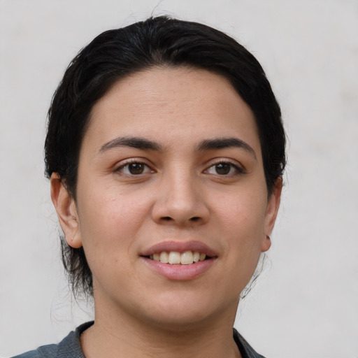 Joyful white young-adult female with short  black hair and brown eyes