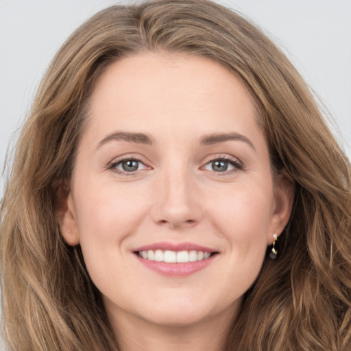 Joyful white young-adult female with long  brown hair and green eyes