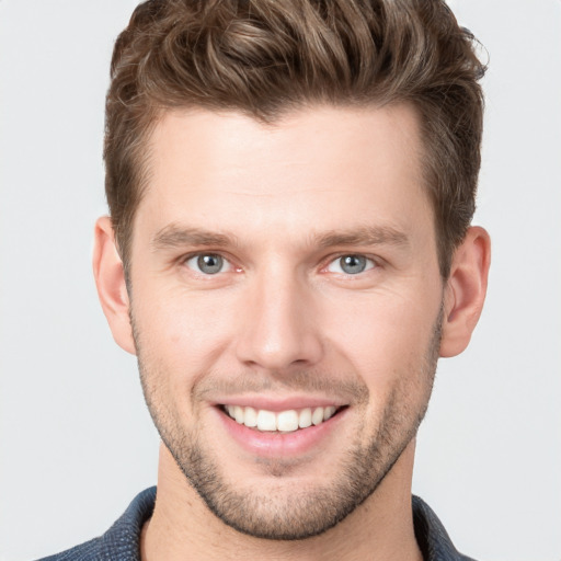 Joyful white young-adult male with short  brown hair and grey eyes