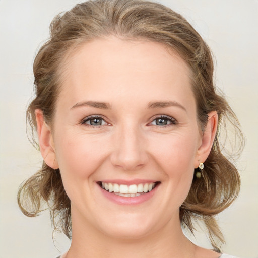 Joyful white young-adult female with medium  brown hair and blue eyes