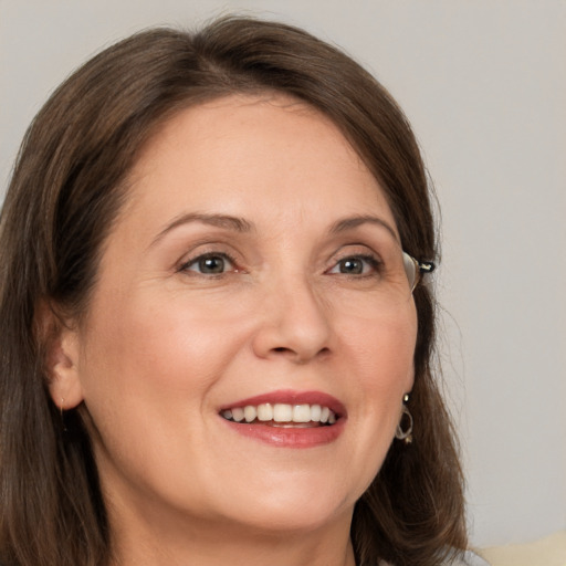 Joyful white adult female with medium  brown hair and grey eyes