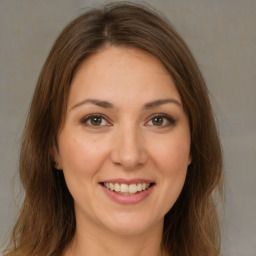 Joyful white young-adult female with long  brown hair and brown eyes