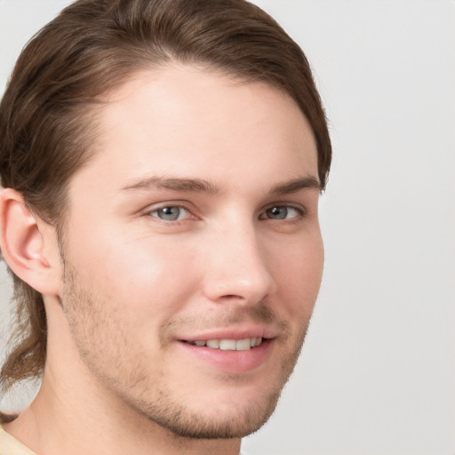 Joyful white young-adult male with short  brown hair and grey eyes