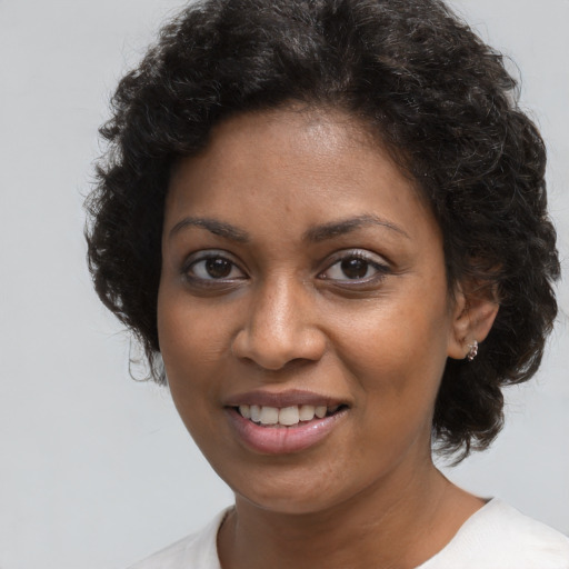 Joyful black young-adult female with short  brown hair and brown eyes