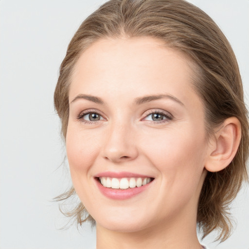 Joyful white young-adult female with medium  brown hair and blue eyes