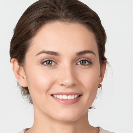 Joyful white young-adult female with medium  brown hair and grey eyes