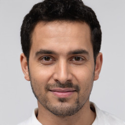 Joyful white young-adult male with short  black hair and brown eyes