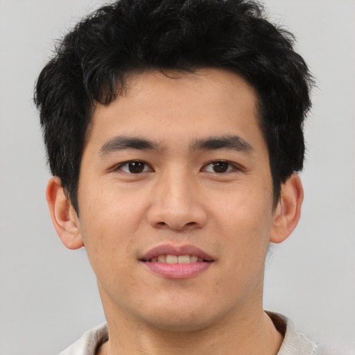 Joyful asian young-adult male with short  brown hair and brown eyes
