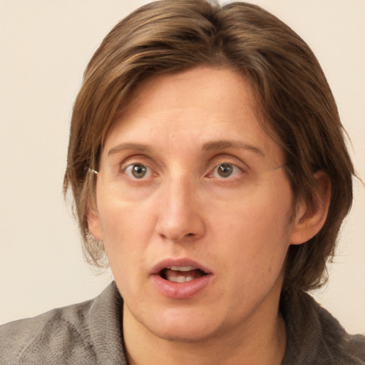 Joyful white adult female with medium  brown hair and grey eyes