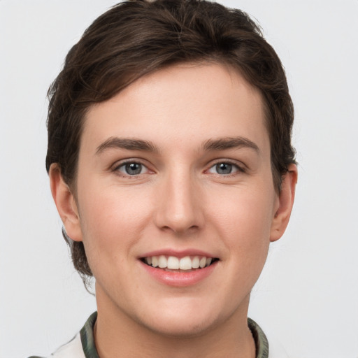 Joyful white young-adult female with short  brown hair and grey eyes