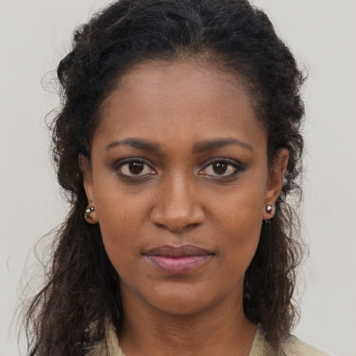 Joyful black young-adult female with long  brown hair and brown eyes