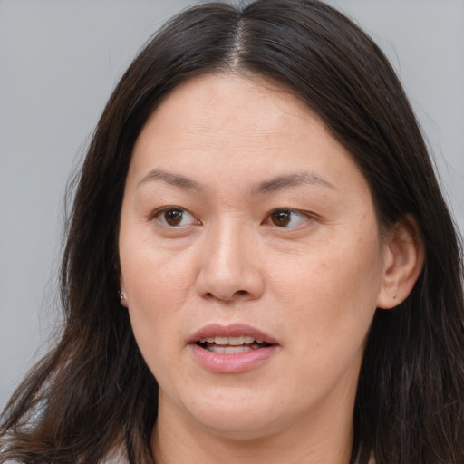Joyful white adult female with long  brown hair and brown eyes
