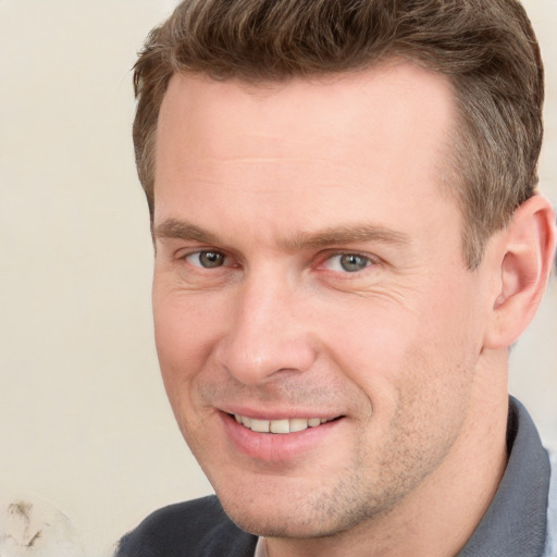 Joyful white adult male with short  brown hair and grey eyes